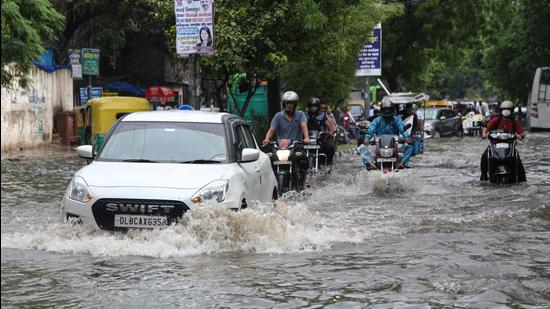 New Delhi, India - July 29, 2021: Commuters make their way past a waterlogged road during heavy rain at Timarpur in New Delhi, India, on Thursday, July 29, 2021. (Photo by Sanchit Khanna/ Hindustan Times) (Sanchit Khanna/HT PHOTO)