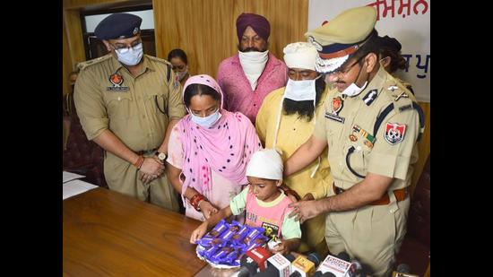 Ludhiana police commissioner Rakesh Agrawal handing over the custody of the rescued child to his family members at the Police Lines on Saturday. (Gurpreet Singh/HT)
