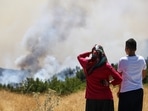 Locals watch a wildfire near the town of Manavgat, east of the resort city of Antalya, Turkey, 