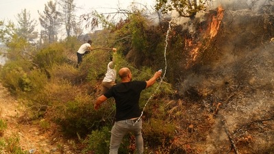 Locals try to extinguish a wildfire near the town of Manavgat, east of the resort city of Antalya, Turkey.  (REUTERS/Kaan Soyturk)