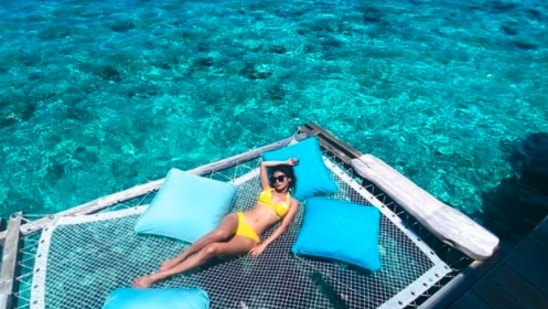 Mouni Roy: The Bengali beauty travelled to the island country in September 2020. In this still, Mouni can be seen basking in the sun wearing a bright yellow bikini.(Instagram/@imouniroy)
