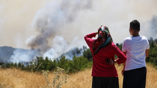 Locals watch a wildfire near the town of Manavgat, east of the resort city of Antalya, Turkey, (REUTERS/Kaan Soyturk)