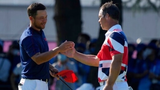 Xander Shauffele of United States, left, is congratulated by Paul Casey of Great Britain after winning Gold in the Men's Golf event at the 2020 Summer Olympics on Sunday, Aug. 1, 2021, in Kawagoe, Japan. (AP Photo/Andy Wong)(AP)