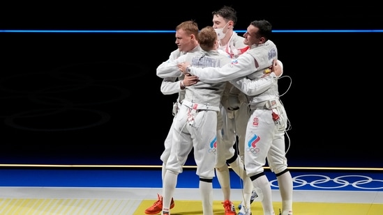 Kirill Borodachev of the Russian Olympic Commettee, left, celebrates with his teammates defeating Alexander Massialas of the United States in the men's Foil team semifinal competition at the 2020 Summer Olympics, Sunday, Aug. 1, 2021, in Chiba, Japan. (AP Photo/Hassan Ammar)(AP)