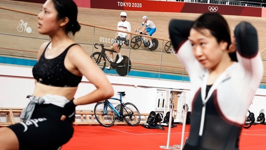 Riders round the track as Kisato Nakamura, left, and Yumi Kajihara, right, both from Japan warm up during a training session inside the Izu velodrome at the 2020 Summer Olympics, Sunday, Aug. 1, 2021, in Izu, Japan. (AP Photo/Thibault Camus)(AP)