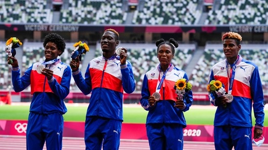 Dominican Republic's 4x400-meter mixed relay team of Anabel Medina Ventura, second right, Marileidy Paulini, left, Lidio Andres Feliz, second left, and Alexander Ogando pose with their silver medals on the podium at the 2020 Summer Olympics, Sunday, Aug. 1, 2021, in Tokyo, Japan. (AP Photo/Francisco Seco)(AP)