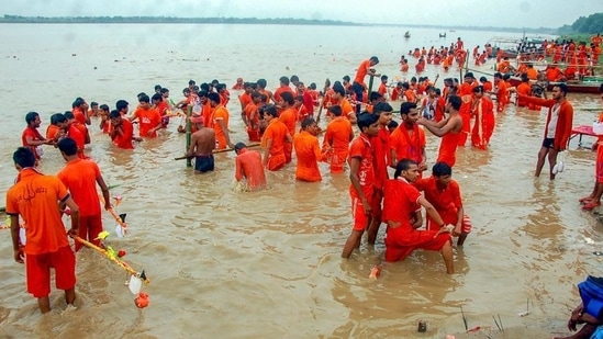 In this 2018 file photo, Kanwariyas take a dip in the river Ganga on the first day of the holy month of Shravan, at Vindhyachal Dham in Mirzapur. (PTI)