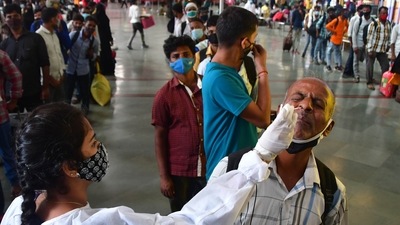 A BMC health worker collects swab samples for Covid-19 test of passengers arriving from outstation trains at CSMT station, in Mumbai. (HT PHOTO) A BMC health worker collects swab samples for Covid-19 test of passengers arriving from outstation trains at CSMT station, in Mumbai. (HT PHOTO)