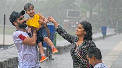 A family enjoying showers at Sukhna Lake in Chandigarh on Monday. (Keshav Singh/HT)