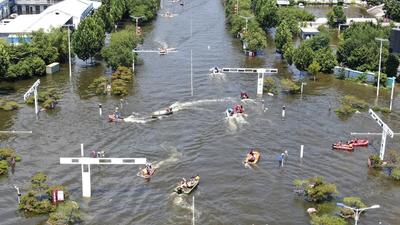 Rescuers use boats to manoeuvre through an intersection as they work to evacuate people from a flooded area in Weihui in central China’s Henan Province, on July 26, 2021. (AP) Rescuers use boats to manoeuvre through an intersection as they work to evacuate people from a flooded area in Weihui in central China’s Henan Province, on July 26, 2021. (AP)