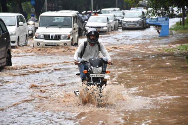 A biker making his way through an inundated road in Sector 29, Chandigarh, on Monday. (Keshav Singh/HT)
