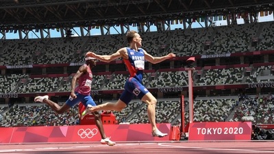 Norway's Karsten Warholm (R) crosses the finish line to win and break the world record ahead of second-placed USA's Rai Benjamin in the men's 400m hurdles final at the Tokyo 2020 Olympic Games (AFP)