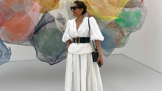On a visit to an art gallery, Sonam Kapoor Ahuja put her sartorial foot forward in a crisp white top that came in rap style and with balloon sleeves and was cinched at the waist with a broad black leather belt. The actor teamed it with a flowy white skirt, completed her attire with a pair of black flat footwear and pulled back her hair into a graceful top knot. She accessorised her look with a pair of black sunglasses and a black sling bag.( Instagram/sonamkapoor)
