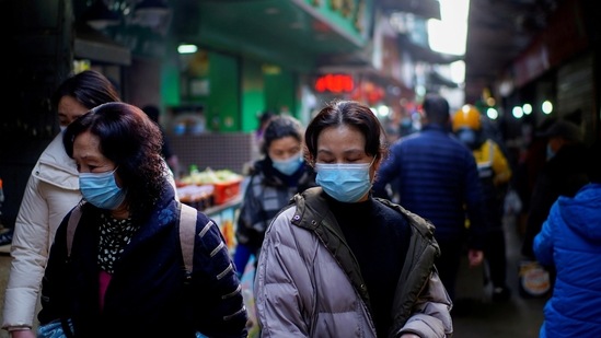 People wearing face masks walk on a street market, following an outbreak of Covid-19 in Wuhan. (Reuters file photo)