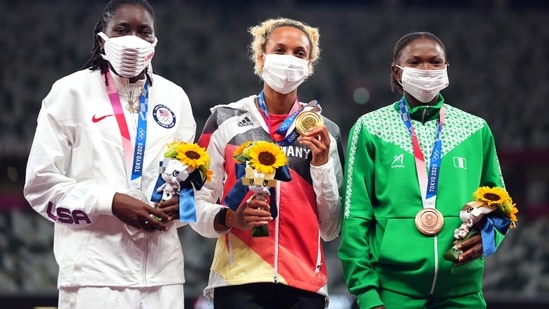 Tokyo 2020 Olympics - Athletics - Women's Long Jump - Medal Ceremony - Olympic Stadium, Tokyo, Japan - August 3, 2021. Gold medallist Malaika Mihambo of Germany celebrates on the podium with silver medallist, Brittney Reese of the United States and bronze medallist, Ese Brume of Nigeria REUTERS/Aleksandra Szmigiel(REUTERS)