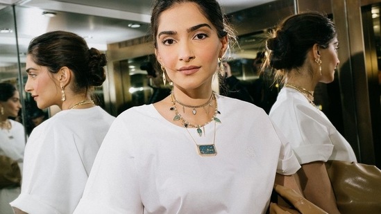 On a date night with hubby Anand Ahuja, Sonam was seen dolled up in another spotless white ensemble that came with a baggy white top and a pleated white skirt which she accessorised with a layered gold necklace, a pair of gold earrings and a tan leather handbag.(Instagram/sonamkapoor)