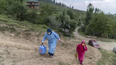 A 'door-to-door' Covid-19 vaccination team go from house to house during a vaccination drive at a village in the Budgam district of Jammu and Kashmir. (Bloomberg)