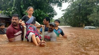 People carry a senior citizen on a chair as they wade through rainwater after heavy rainfall causes flood in Chiplun on July 22. (Hindustan Times) People carry a senior citizen on a chair as they wade through rainwater after heavy rainfall causes flood in Chiplun on July 22. (Hindustan Times)