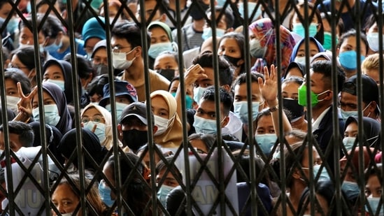 People wearing masks stand in line wait to receiving a dose of the vaccine against Covid, during a vaccination program at the provincial govt building in Medan, North Sumatra province, Indonesia.(via Reuters)