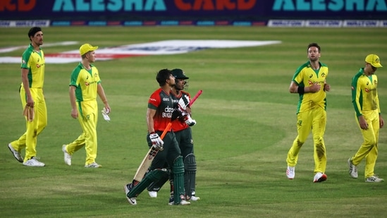 Afif Hossain and Nurul Hasan walk past Australia's players after winning their match(REUTERS)