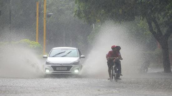 Vehicles making their way through a waterlogged road in Sector 16, Chandigarh, on Wednesday. (Ravi Kumar/HT)
