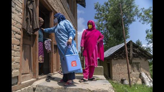 A 'door-to-door' Covid-19 vaccination team speaks to a resident during a vaccination drive at a village in the Budgam district of Jammu and Kashmir. (Bloomberg)