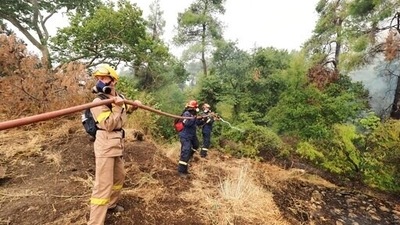 Firefighters try to extinguish a wildfire in Kechries village. Forest fires fuelled by a protracted heat wave raged overnight and into Thursday in Greece, threatening the archaeological site at the birthplace of the modern Olympics and forcing the evacuation of dozens of villages.  (AP)