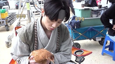 BTS member Jungkook with a chicken.