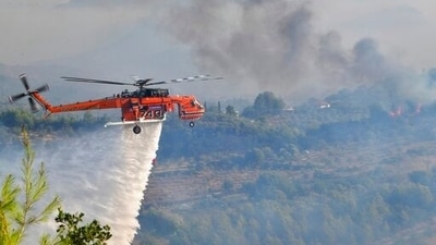 A helicopter drops water during a wildfire in ancient Olympia, western Greece on August 5.  2021. Fire crews fight elsewhere to keep flames away from the birthplace of the ancient Olympic Games as the country sweltered under a record heat wave.  (AP)