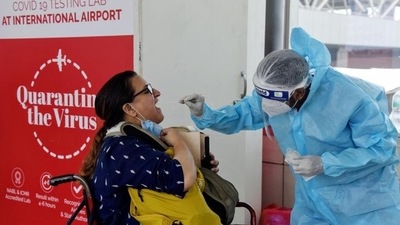 A medic collects swab samples from a passenger coming from outside of India, for the Covid-19 RT PCR test, at Indira Gandhi International airport, in New Delhi. (ANI File Photo)