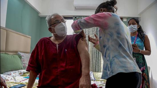 A health worker inoculates a senior citizen at his residence with a dose of Covaxin during a door-to-door vaccination drive in Mumbai. (AFP)
