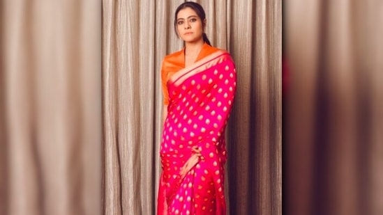 Kajol gave a trendy look to her traditional pink saree by pairing it with an orange oval neck blouse.(Instagram/@kajol)