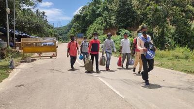 A group of people cross the Assam-Mizoram border on foot after authorities refused to allow private vehicles to cross (HT Photo) A group of people cross the Assam-Mizoram border on foot after authorities refused to allow private vehicles to cross (HT Photo)