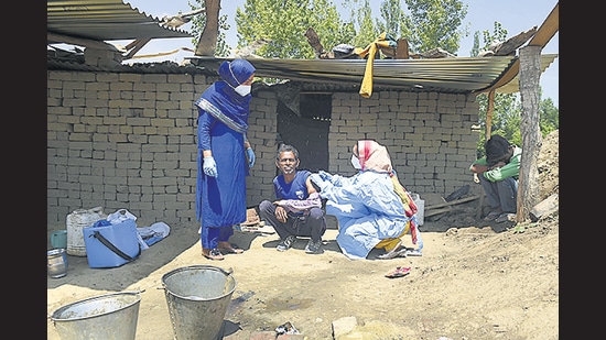 Health workers visit the remote Mamgund Gonipora village of Budgam district to vaccinate local residents, on Friday. (PTI)