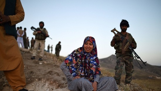 Salima Mazari, a female district governor in male-dominated Afghanistan, looking on from a hill while accompanied by security personnel. (AFP)