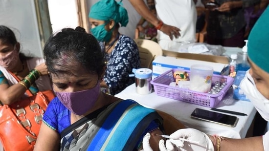 A beneficiary gets inoculated against Covid-19 inside the Aarey Milk Colony, in Mumbai. (Satish Bate/HT photo)