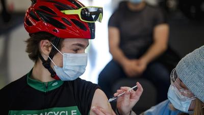 A cyclist receives a dose of the Pfizer-BioNTech Covid-19 vaccine at the Gilles Villeneuve racetrack in Montreal, Quebec, Canada. (Bloomberg)