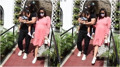 Neha flaunted her baby bump in the outfit, which she teamed with sunglasses, white sneakers, a face mask, a black and white tote bag, and open locks. (Varinder Chawla)