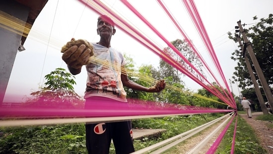 A worker prepares a kite-flying string ahead of Independence Day celebration, in Jammu. (ANI)
