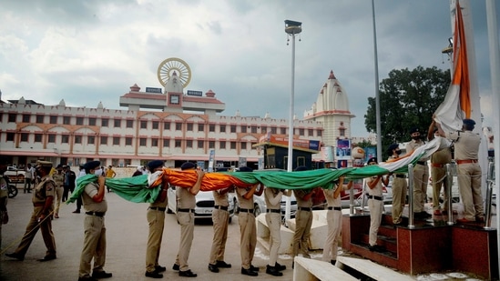 Security personnel hoist the national flag at Cantt Station Varanasi as part of 'Amrit Mahotsav' on the 75th anniversary of Independence Day, in Varanasi on August 6.(PTI)