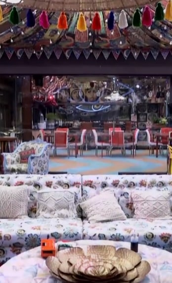 The sitting area has a huge printed white couch strewn with embroidered cushions.