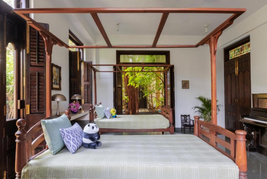 The bedrooms have wooden furniture and overlook the lush surroundings.