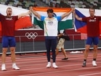 Neeraj Chopra of India celebrates with his national flag after winning gold alongside silver medalist Jakub Vadlejch of Czech Republic and bronze medalist Vitezslav Vesely of Czech Republic.