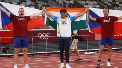 Neeraj Chopra of India celebrates with his national flag after winning gold alongside silver medalist Jakub Vadlejch of Czech Republic and bronze medalist Vitezslav Vesely of Czech Republic. (REUTERS)