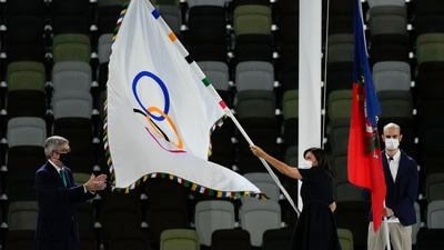 Paris mayor Anne Hidalgo, right, holds the Olympic flag next International Olympic Committee's President Thomas Bach, left, during the closing ceremony in the Olympic Stadium at the 2020 Summer Olympics, Sunday, Aug. 8, 2021, in Tokyo, Japan. (AP Photo/Charlie Riedel) (AP)