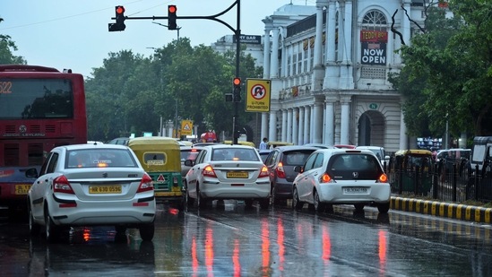 Vehicles stop at a traffic signal amid rain showers at Connaught Place in New Delhi on August 8. (Raj K Raj/Hindustan Times)