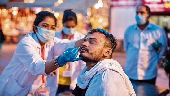 A health worker collects a nasal swab sample to test for Covid-19 during the Kumbh on April 12.(AFP)