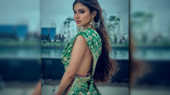 With smokey eyes and nude lips, Mouni accessorised her saree with green long earrings.(Instagram/@imouniroy)
