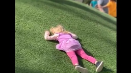 The image shows the little girl lying on the field.