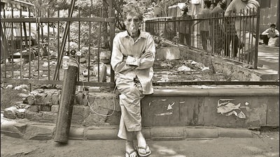 A Covid-19 patient on oxygen support waits outside LNJP Hospital for admission amid a shortage of beds, in New Delhi, in April. (HT Archive)